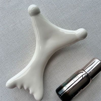 OEM/ODM Gua Sha em forma de X de cerâmica de raspagem Massagista Salão de beleza essencial para relaxamento facial